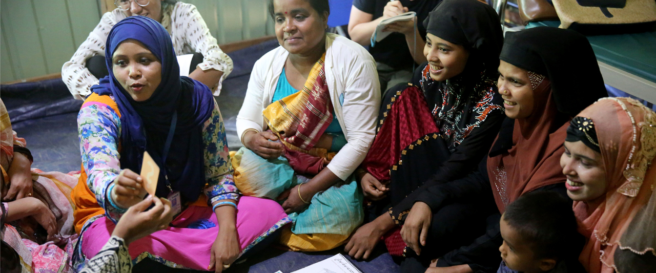 Learning through playing: ‘Kele-Kele Shiki’ board game helps normalize family planning for Rohingya refugees Women sit around the Kele-Kele board game