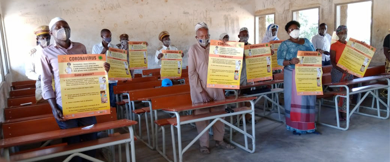 Participants hold up coronavirus protocol signs