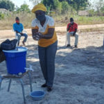 Woman washing hands using outdoor station.