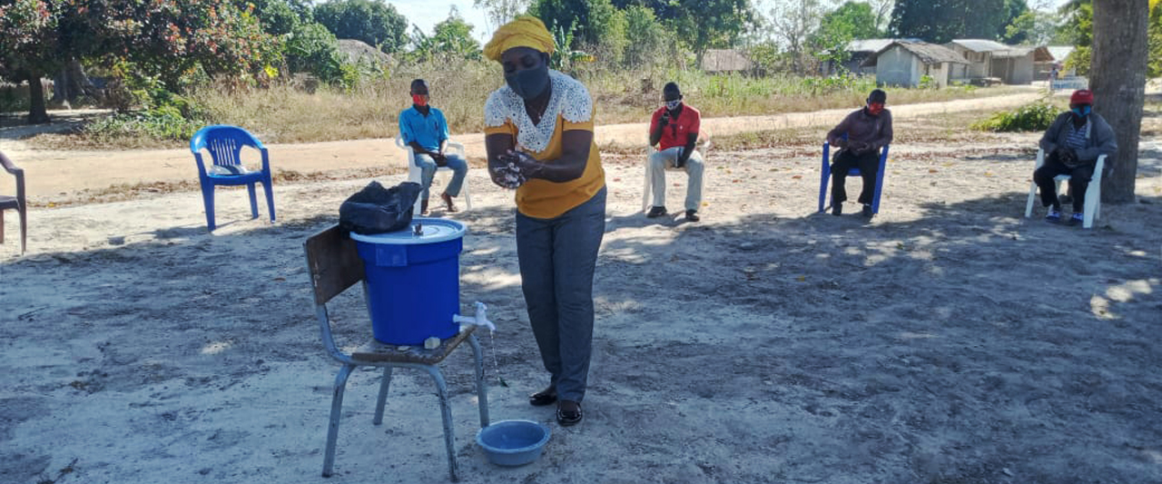 Woman washing hands using outdoor station.