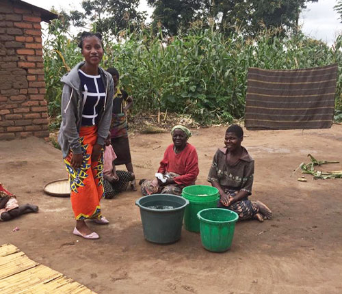 Tisungage Sitima distributing soap to villagers