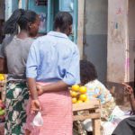 People shop outdoors in a market in Kenya