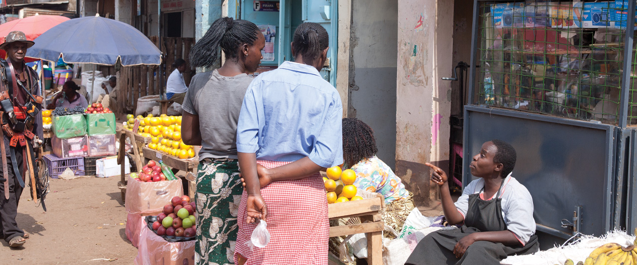 People shop outdoors in a market in Kenya