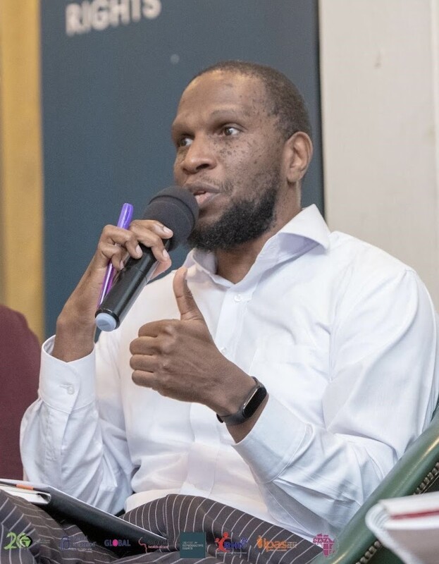 Ernest Nyamato holding microphone and speaking to an audience.