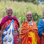 The women of the beehive project stand near the hives.