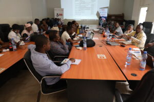 a group of people sitting at a classroom-style table and having a discussion