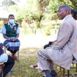 Amos Simpano speaking with youth outside